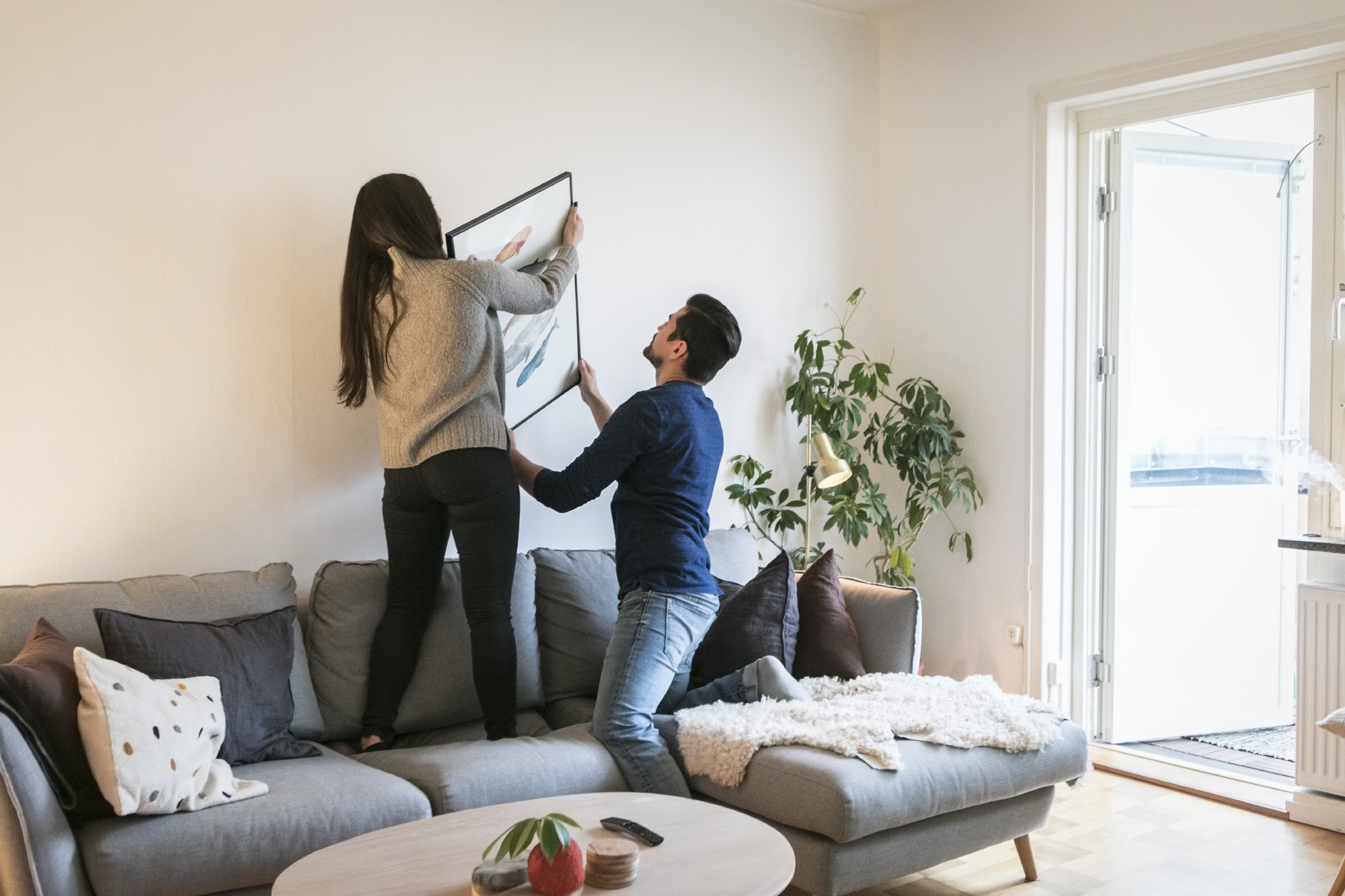 Jong koppel hangt kader aan de muur